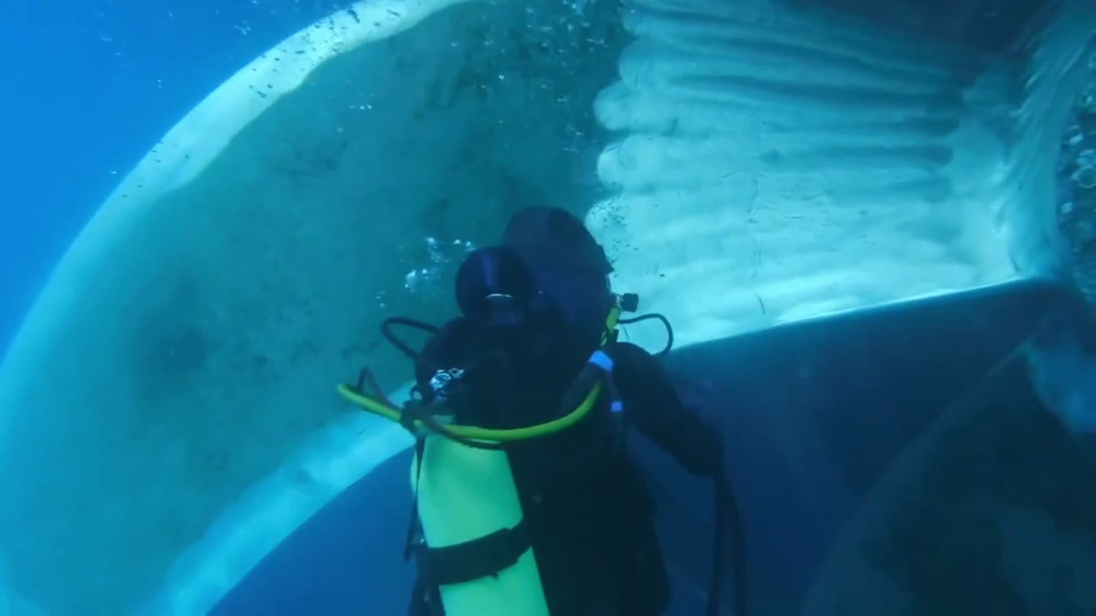 Diver polishing a ship's propeller blade underwater